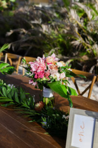 Pink Tropical Beach Wedding Reception Centerpieces with Long Feasting Table and Greenery Garland | St Pete Florist Save The Date Florida