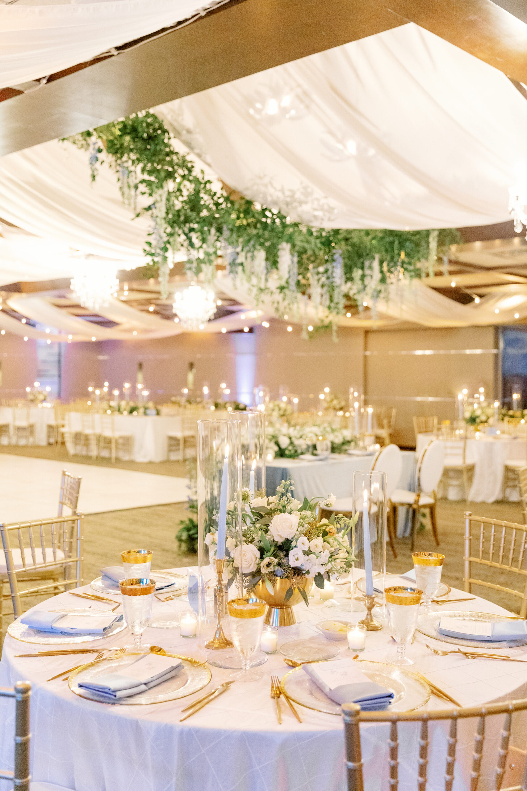 Elegant Reception Decor Ideas | Romantic Indoor White and Gold Spring Wedding Reception with Gold Chiavari Chairs and White Ceiling Drapery with Hanging Floral Arrangements | Sarasota Wedding Planner MDP Events | Florist Botanica International Design Studio | Venue Marie Selby Gardens