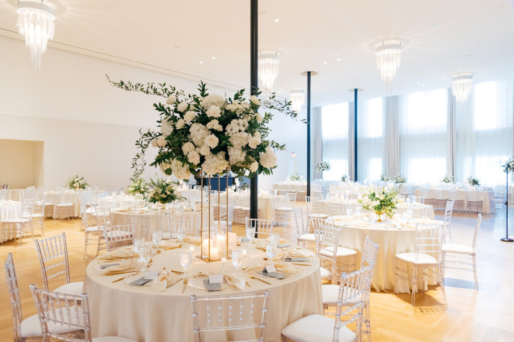 Romantic White Neutral Wedding Reception Inspiration, Round Tables with Clear Chiavari Chairs, Tall Floral Centerpieces with Greenery and White Hydrangeas, Gold Table Linens | Tampa Bay Wedding Venue Hotel Haya | Kate Ryan Event Rentals | Planner Parties A La Cart | Florist Bruce Wayne Florals