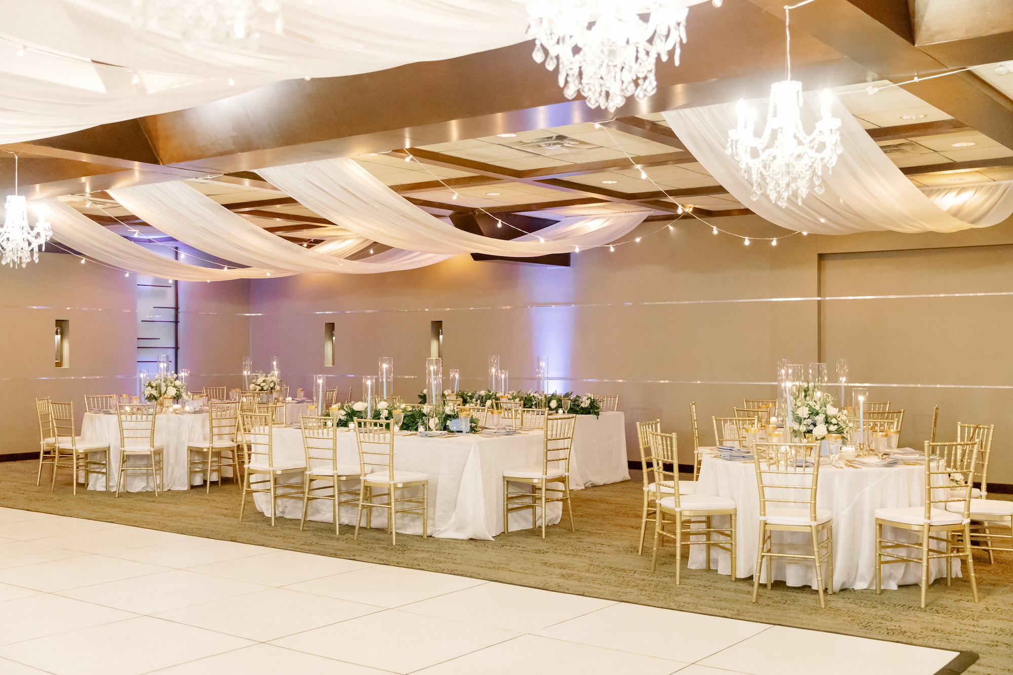 Classic Gold and White Wedding Reception Inspiration with Ceiling Draping, Chandeliers, and White Dance Floor