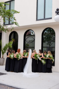 Bride and Bridesmaids in All Black Floor Length Gowns with White and Greenery Bouquets | Lifelong Photography