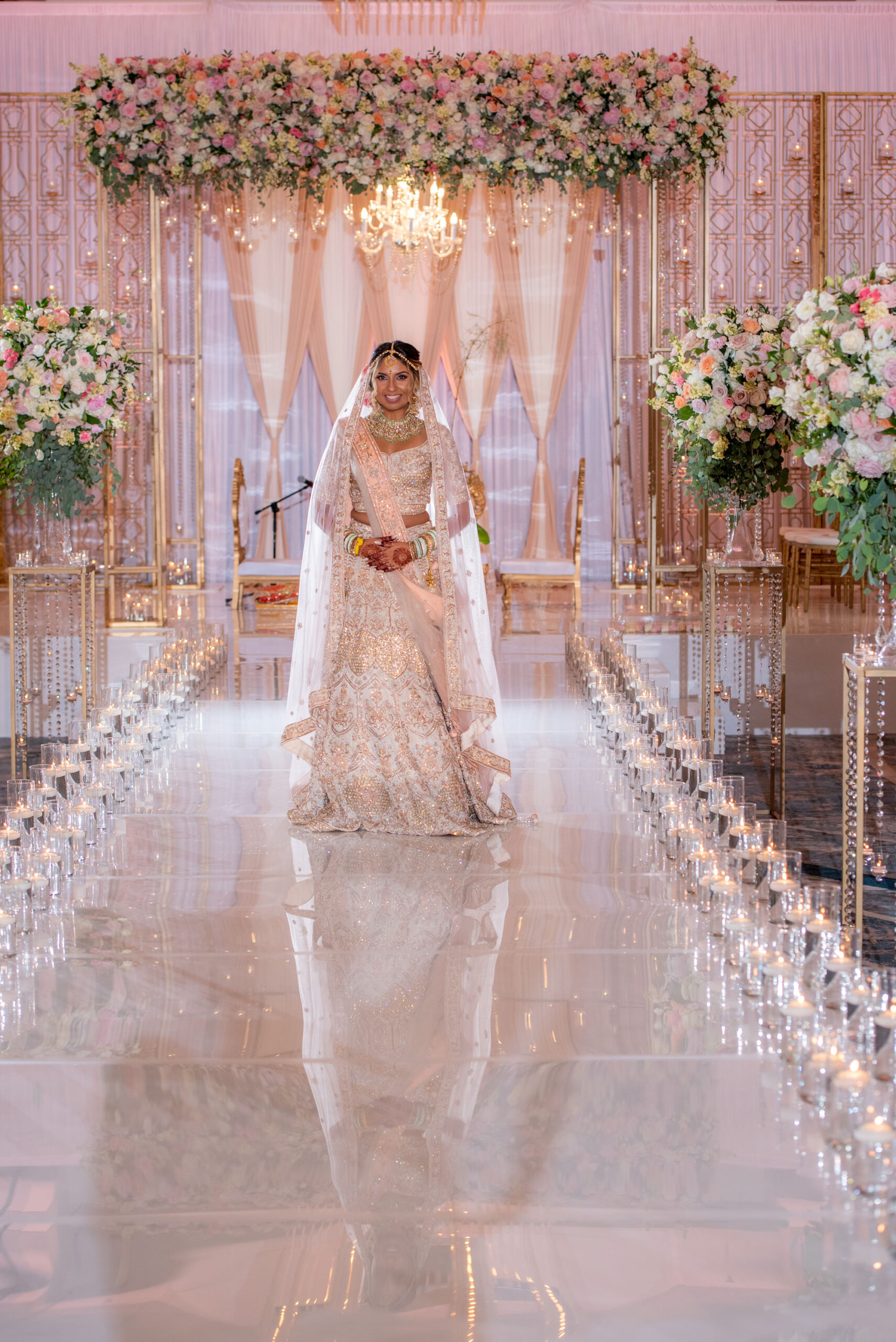 Tampa Bay Bride In Luxurious Wedding Ceremony, Lush Floral Arrangements with White, Pink and Red Florals, Candlelight Aisle with Draping and Chanderlier Lighting, Wearing Ivory and Rose Gold Saree | Michele Renee the Studio | Florida Wedding Venue Hilton Downtown Tampa