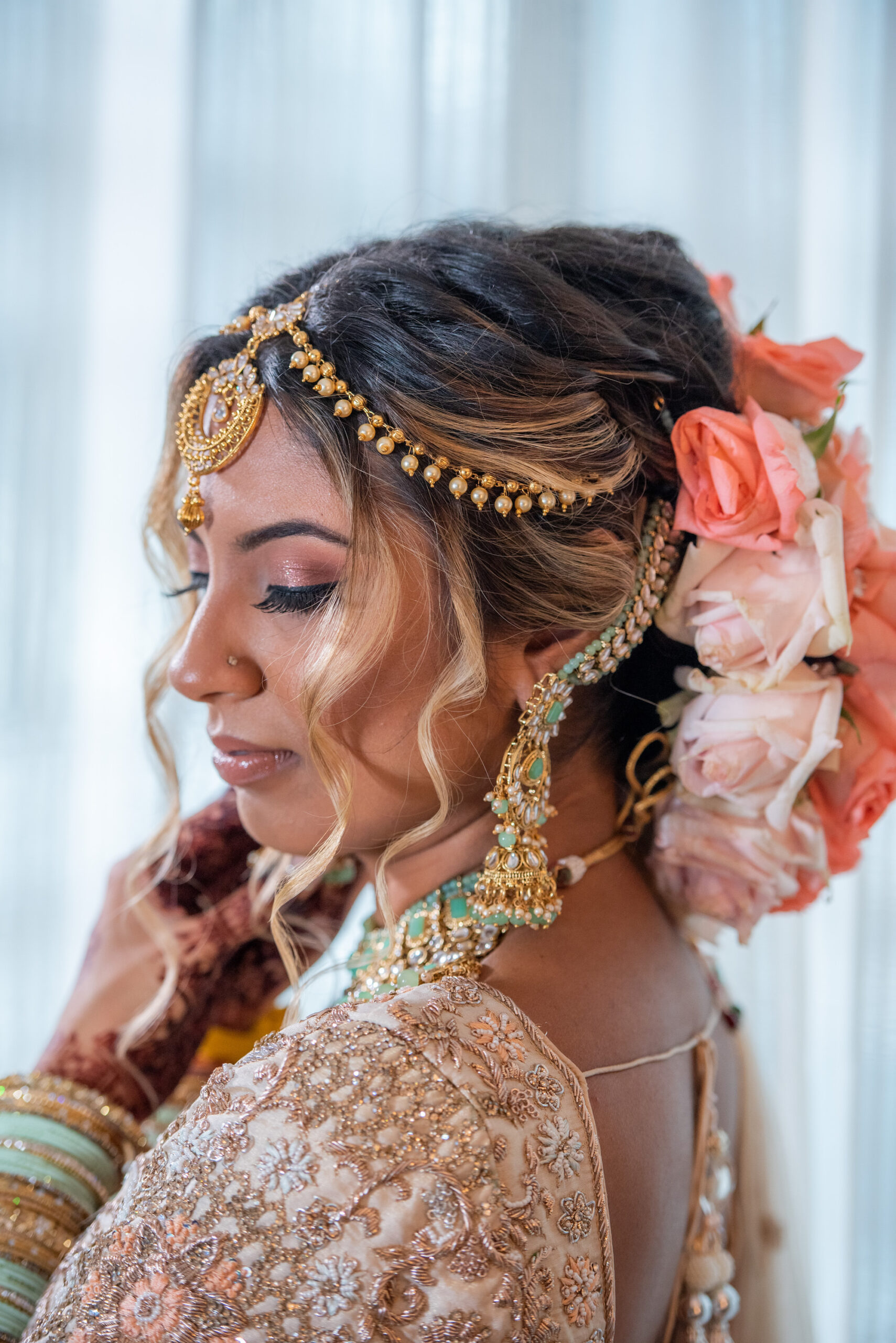 Florida Bride Getting Ready for Indian Wedding, Wearing Head Jewelry Chain, Gold Headpiece with Pink and Coral Rose Flowers in Hair | Tampa Bay Hair and Makeup Artist Michele Renee the Studio