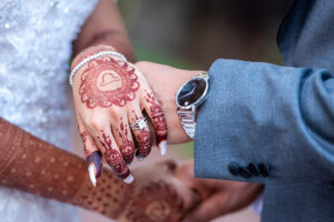 Bride and Groom Hold Hands, Henna Tattoo Detailing, Princess Cut Diamond Engagement Ring, Platinum Watch with Black Face