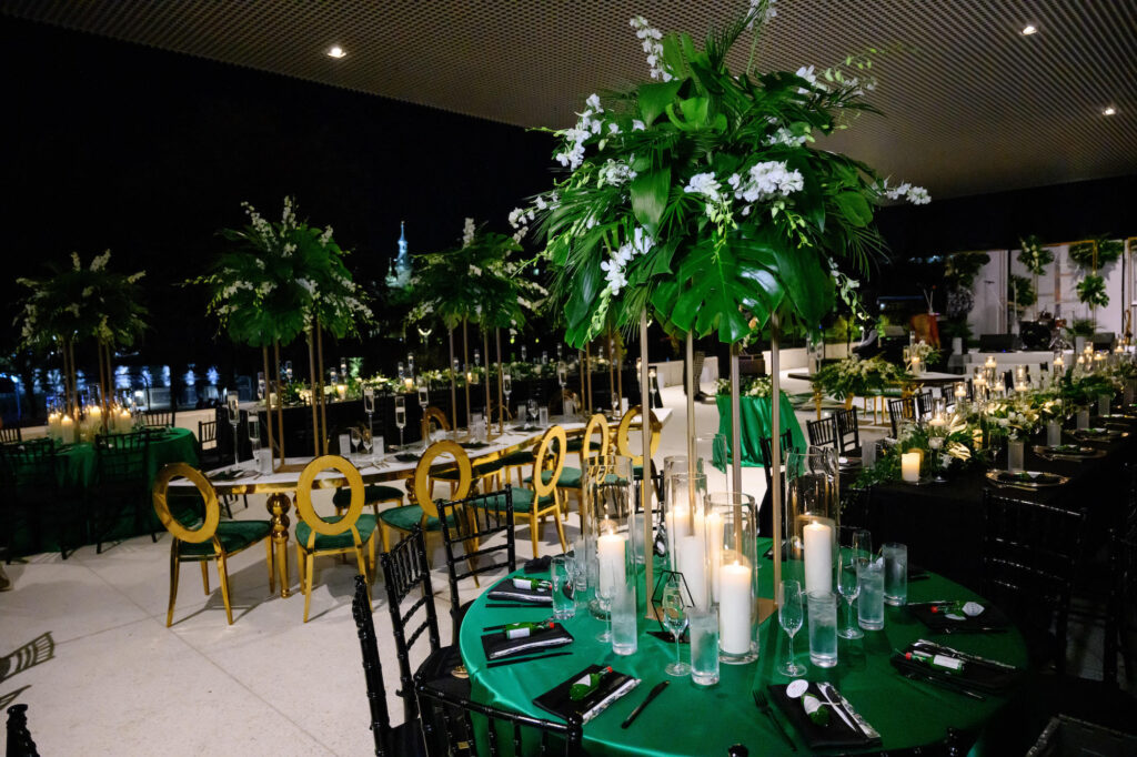 Modern Glamorous Gold and White Serpentine Table with Louis Pop Chairs and Velvet Cushions | Tall Gold Flower Stand with Monstera, White Stock Flowers | Emerald Green and Black Wedding Inspiration | Tampa Bay Florist FH Events | A Chair Affair