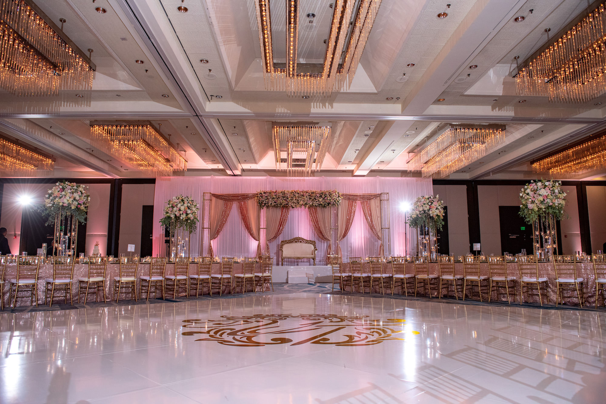 Modern Luxurious Ballroom Wedding Reception, White Dance Floor with Gold Monogram, Rose Gold Linens and Chiavari Chairs, Tall Floral Centerpieces on Long Feasting Tables | Florida Wedding Venue Hilton Downtown Tampa