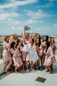 Bride and Bridesmaids in Pink Robes with Mimosas Getting Ready Rooftop Wedding Portrait Ideas