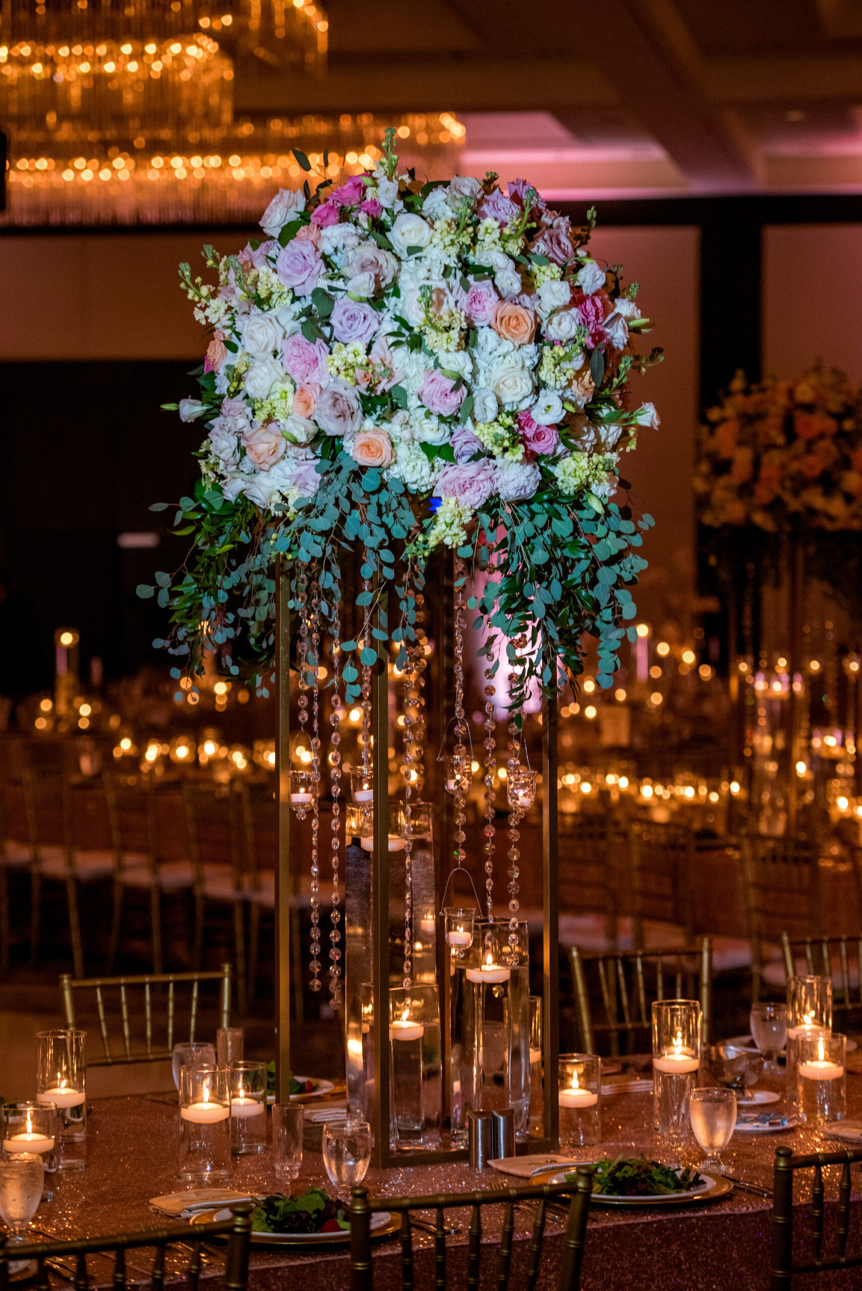Modern Luxurious Ballroom Wedding Reception Decor, Tall Floral Centerpiece, Pink Flowers, Red Roses, White Florals, Ivory Stems, Tall Geometric Stand with Crystals, Sequined Table Linens