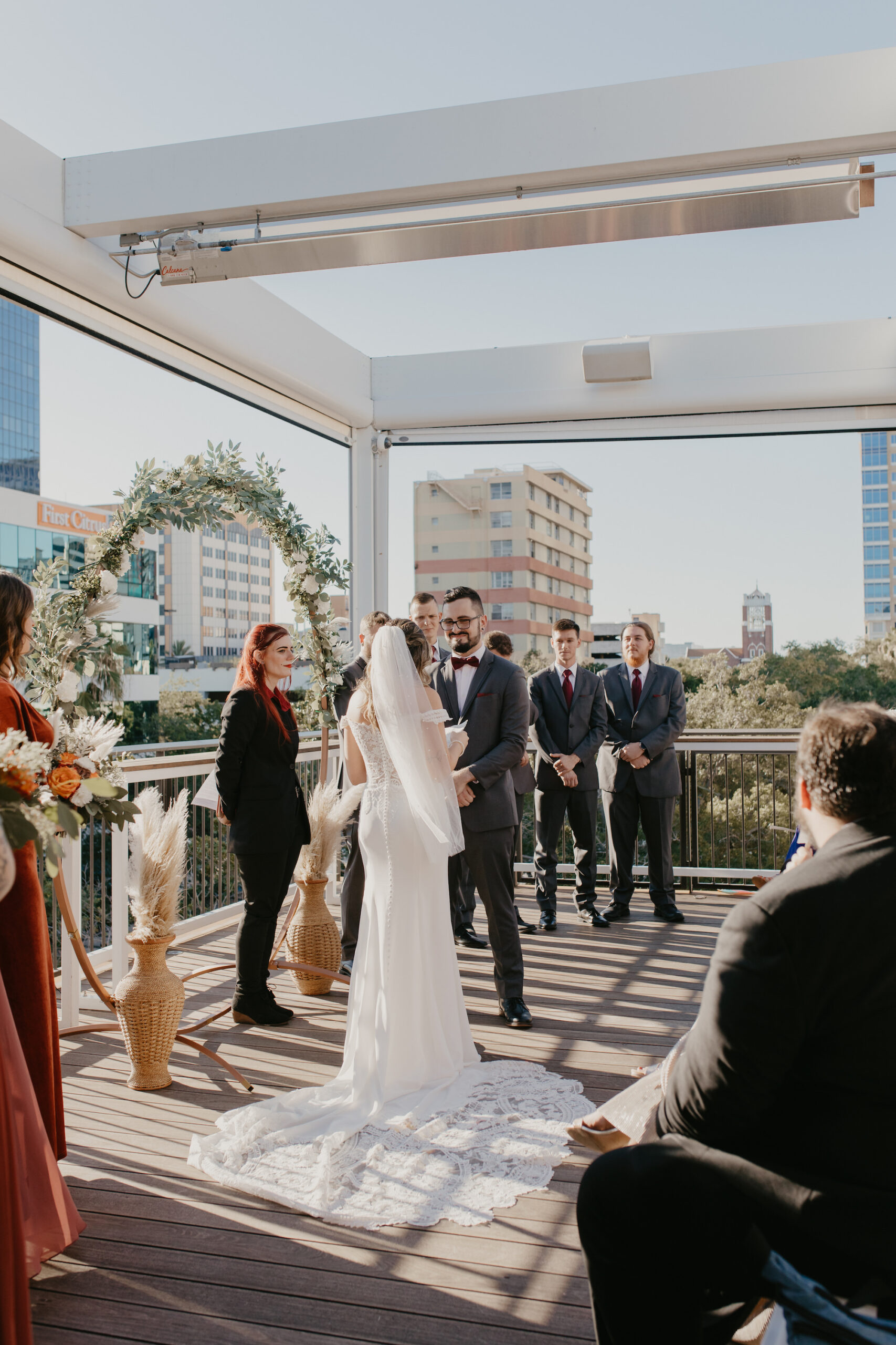 Bride and Groom De Santo Rooftop Wedding Ceremony Ideas with Greenery Circular Arch | St. Petersburg Venue Red Mesa Events