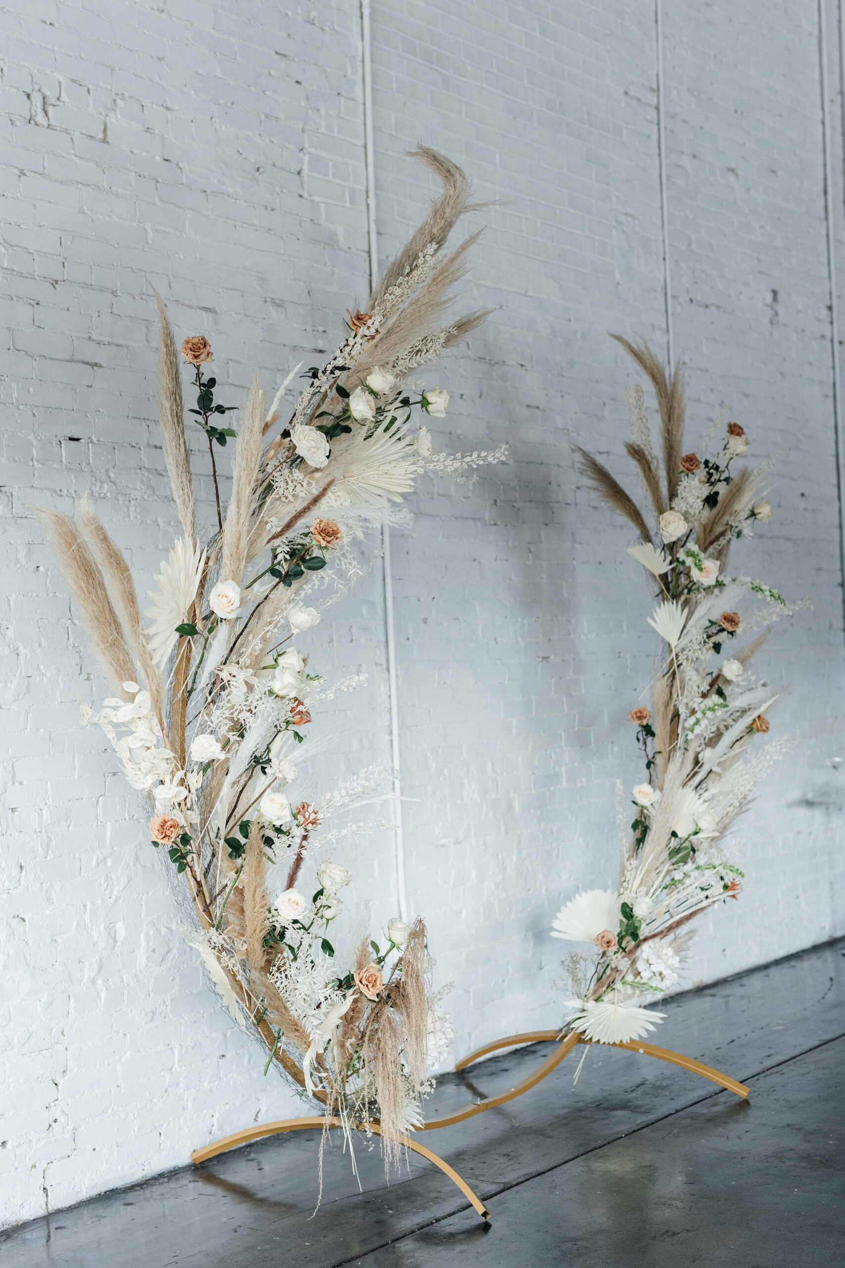 Asymmetrical Round Boho Arch with Boho Pampas Grass White Palm Frond Floral Arrangements | Bohemian Ceremony Inspiration
