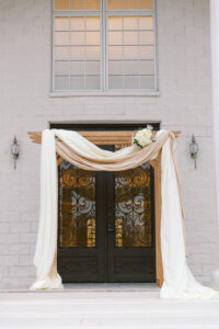 Vintage Old Hollywood Gatsby Inspired Wedding Ceremony, Arch Draped With Neutral Toned Linens and Cream Floral Bouquet | Florida Luxury Wedding Venue The Whitehurst Gallery