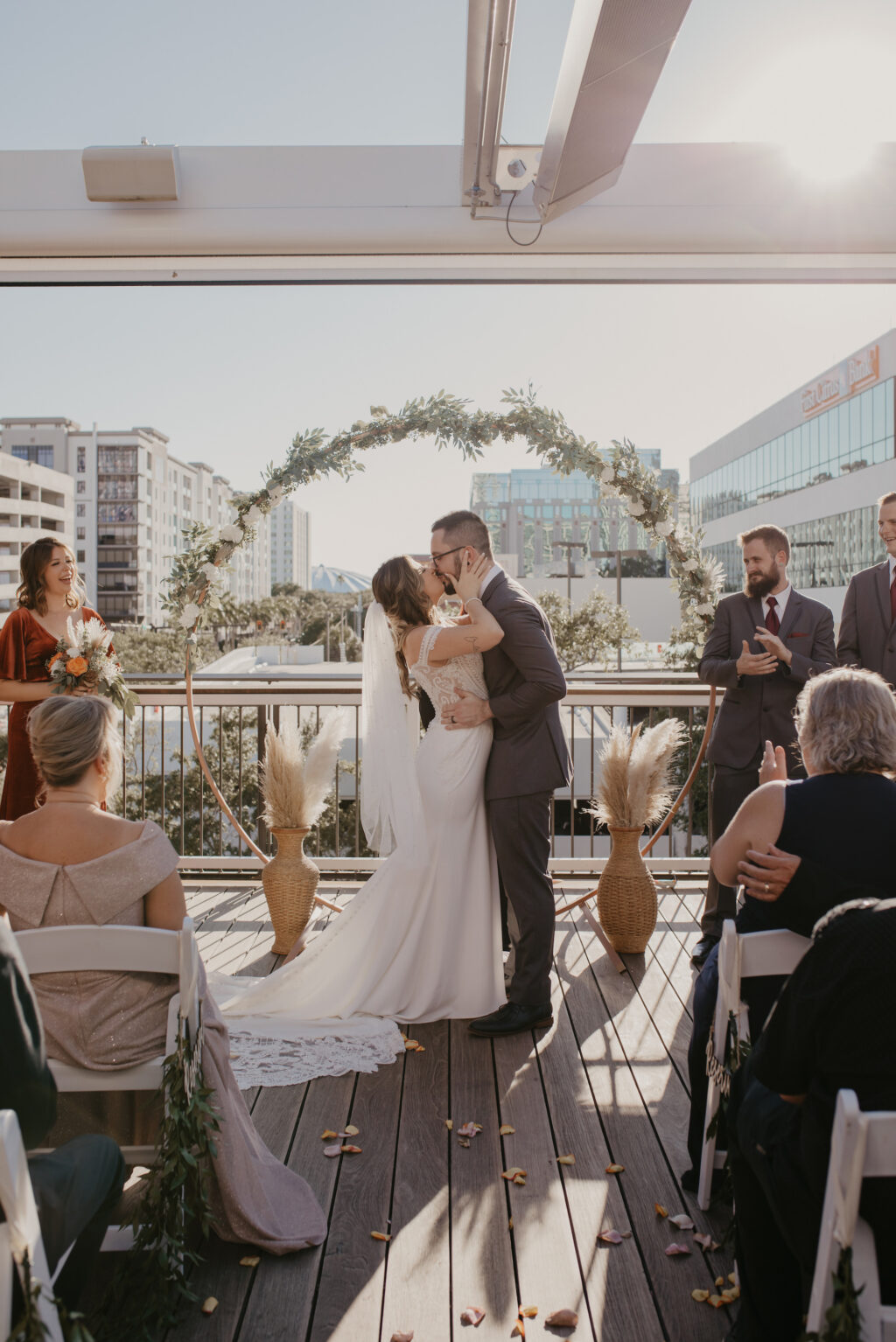 Bride and Groom De Santo Rooftop Wedding Ceremony Ideas with Greenery Circular Arch | De Santo Rooftop Ceremony | St Petersburg Venue Red Mesa Events | Planner Coastal Coordinating