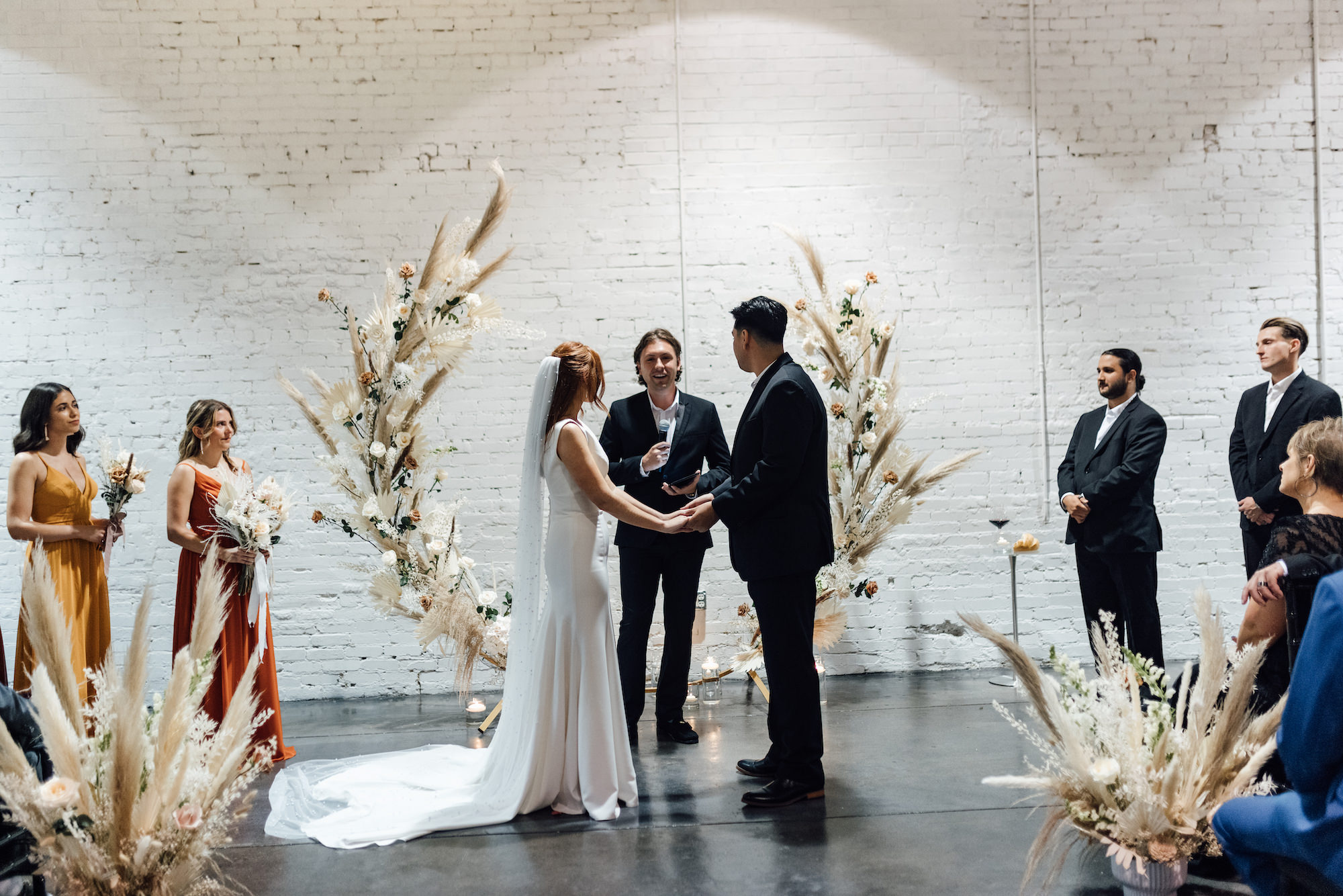 Asymmetrical Round Boho Arch with Boho Pampas Grass White Palm Frond Floral Arrangements | Lakeland Industrial Wedding Venue with White Brick Walls Haus 820