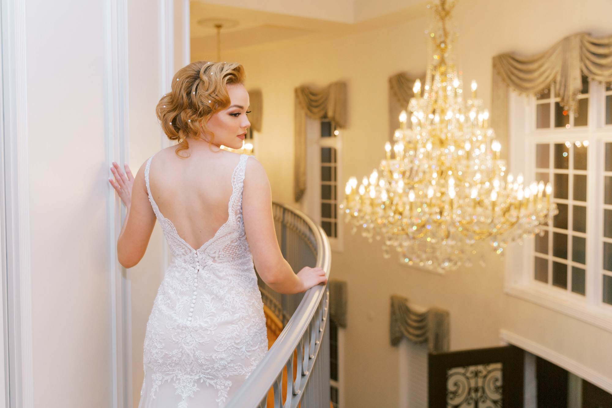 Vintage Old Hollywood Gatsby Inspired Bride In Front of Chandelier | Tampa Bay Wedding Hair and Makeup Artist Femme Akoi Beauty Studio | Tarpon Springs Wedding Venue The Whitehurst Gallery