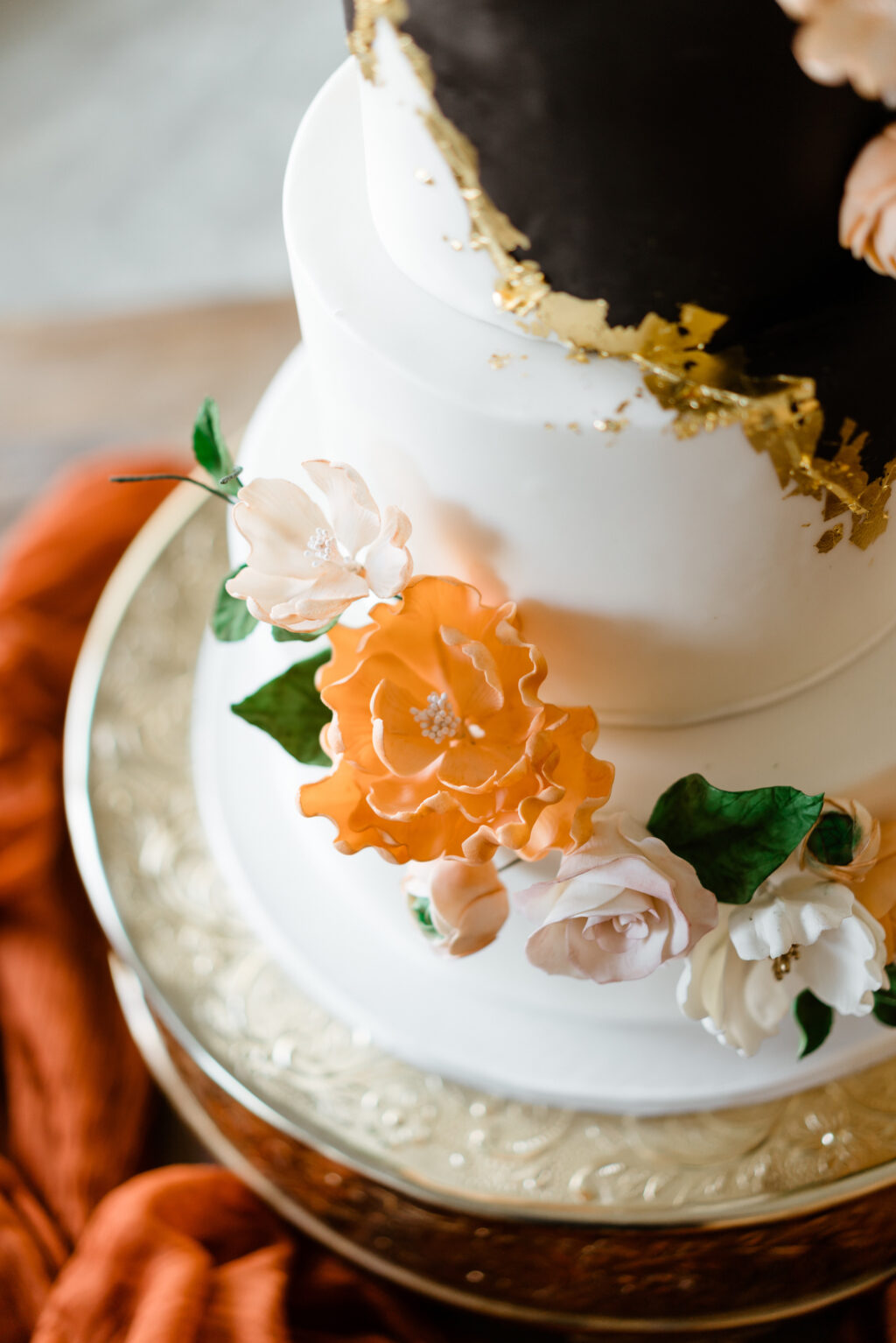 Modern Four-Tiered Black, White, and Gold Wedding Cake On a Gold Cake Stand | Tampa Bay Wedding Cake Tampa Bay Cake Company