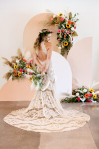 Geometric Retro Boho Wedding Ceremony Altar Backdrop | Keyhole Ivory and Nude Lace Wedding Dress with Chapel Train | Boho Pampas Grass, Sunflower, White and Pink Rose Floral Arrangement Inspiration | Tampa Bay Rentals Outside The Box