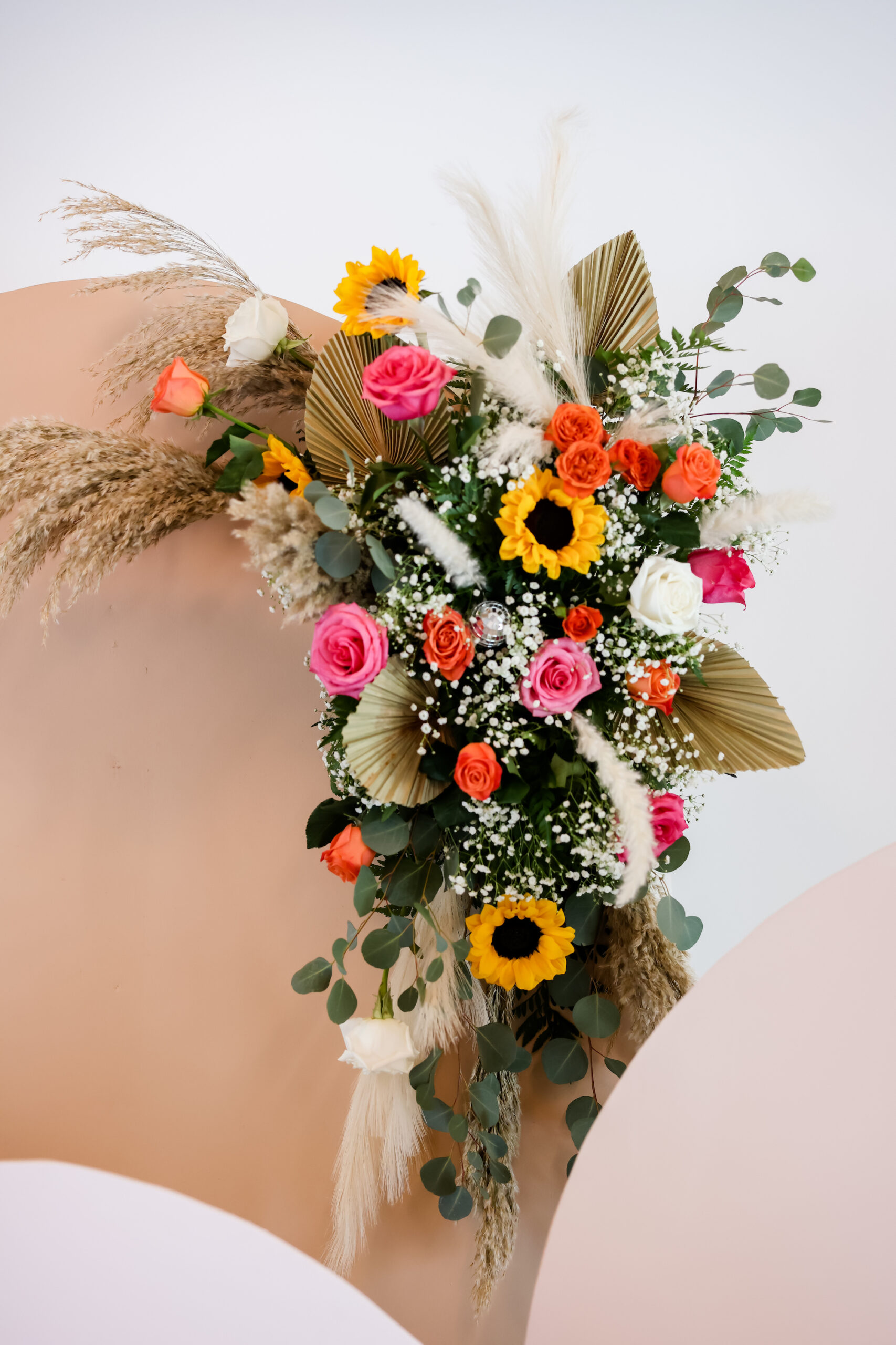Boho Pink, Orange, and White Roses with Sunflowers, Palm Leaves, Pampas Grass, Baby's Breath, and Wheat Wedding Floral Ceremony Arch Arrangement Ideas
