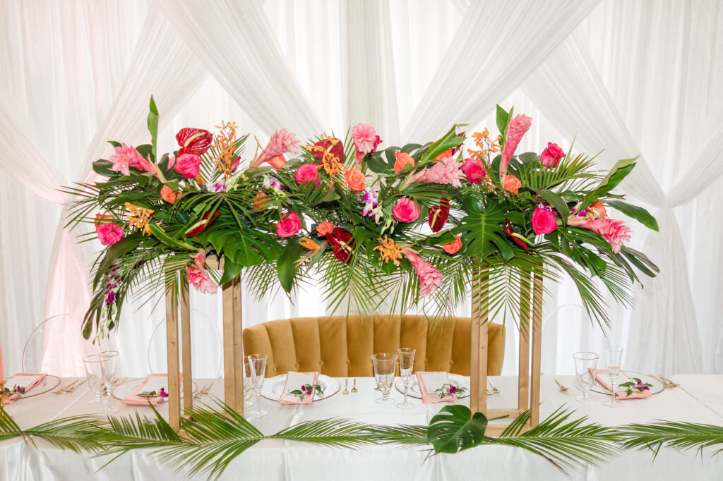 Tropical Pink and Orange Wedding Reception Inspiration with Long Feasting Head Sweetheart Table | Pink Taper Candles | Tampa Bay Florist Save the Date Florida