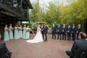 Bride and Groom Wedding Outdoor Bamboo Courtyard Ceremony | Navy Groomsman Suits | Light Sage Green Bridesmaids Dress Inspiration | St Petersburg Venue NOVA 535 | Photographer Carrie Wildes Photography