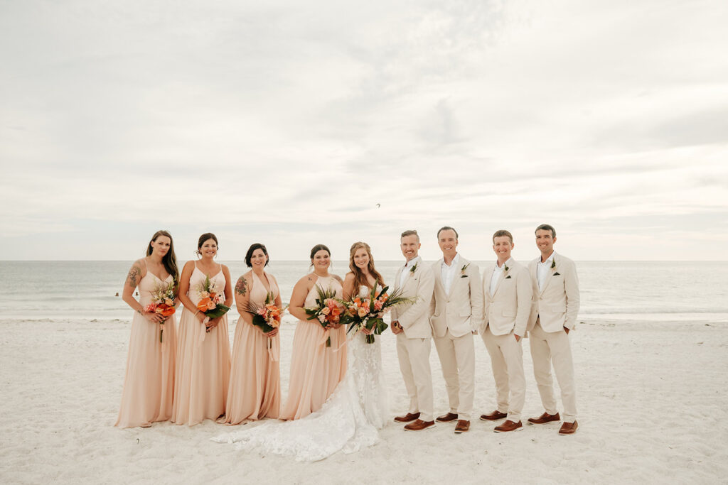 Mismatching Peach Bridesmaids Dresses | Tan Groomsmen Suits | Tropical Beach Wedding Attire Ideas and Peach Bouquet | Sarasota Wedding Florist Save the Date Florida