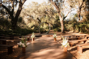 Enchanted Forest Wedding Ceremony | Rustic Wooden Benches | Round Arch with White Flowers and Greenery | Tampa Bay Venue Cross Creek Ranch