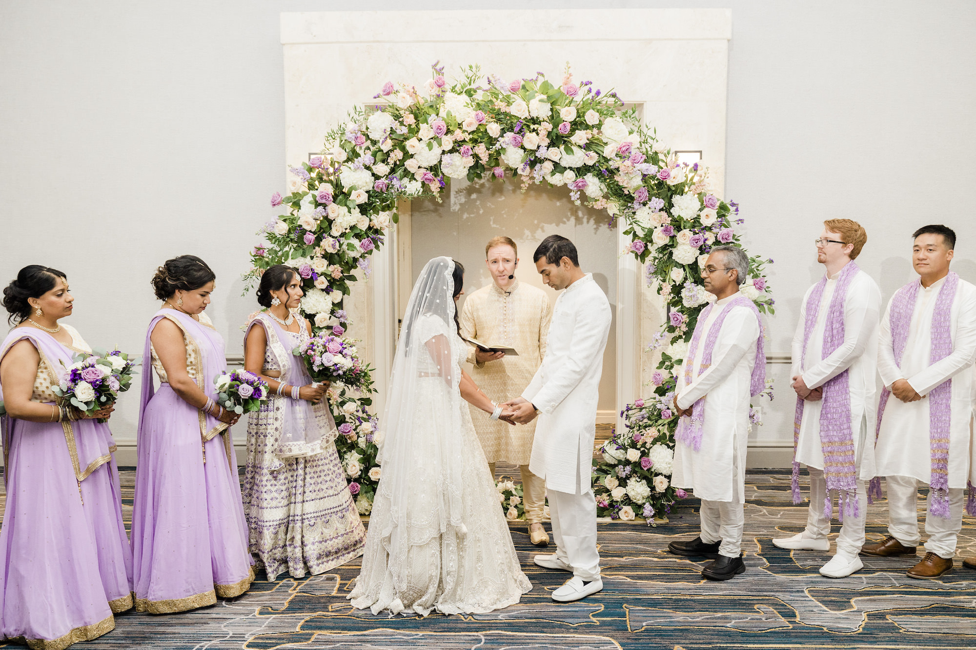 Bride and Groom Vow Exchange | Round Flower Arch Ideas with Purple and Blush Roses, White Hydrangeas, and Greenery | Lavender Indian Wedding Ceremony Inspiration