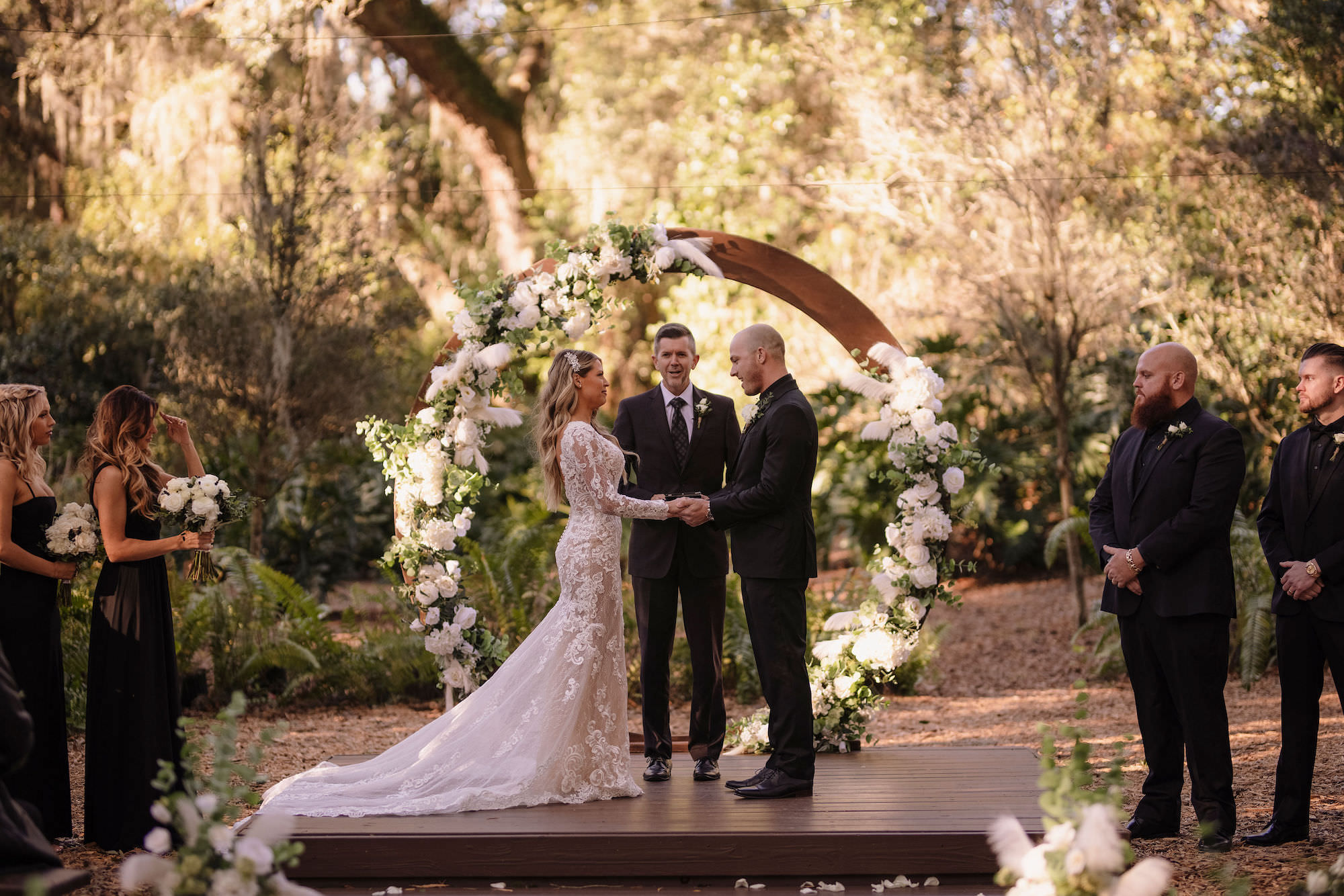 Bride and Groom Reading Wedding Vows with Circular Wooden Arch and White Flowers | Tampa Bay Wedding Venue Cross Creek Ranch