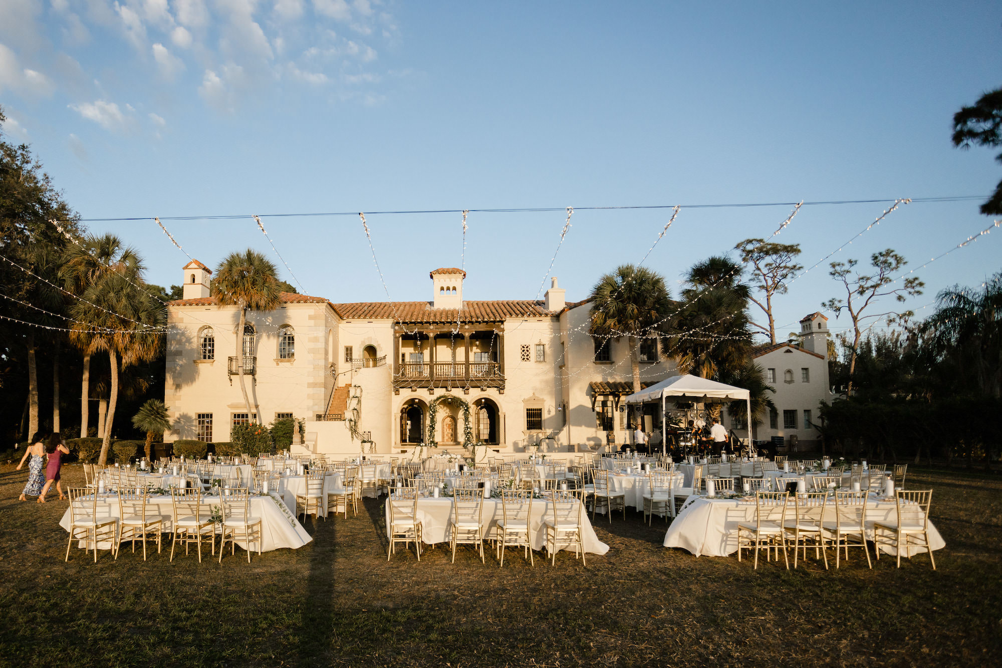 Sunset Outdoor Lawn Wedding Reception | Market lights | Gold Chiavari Chairs | Sarasota Venue Powel Crosley Estate