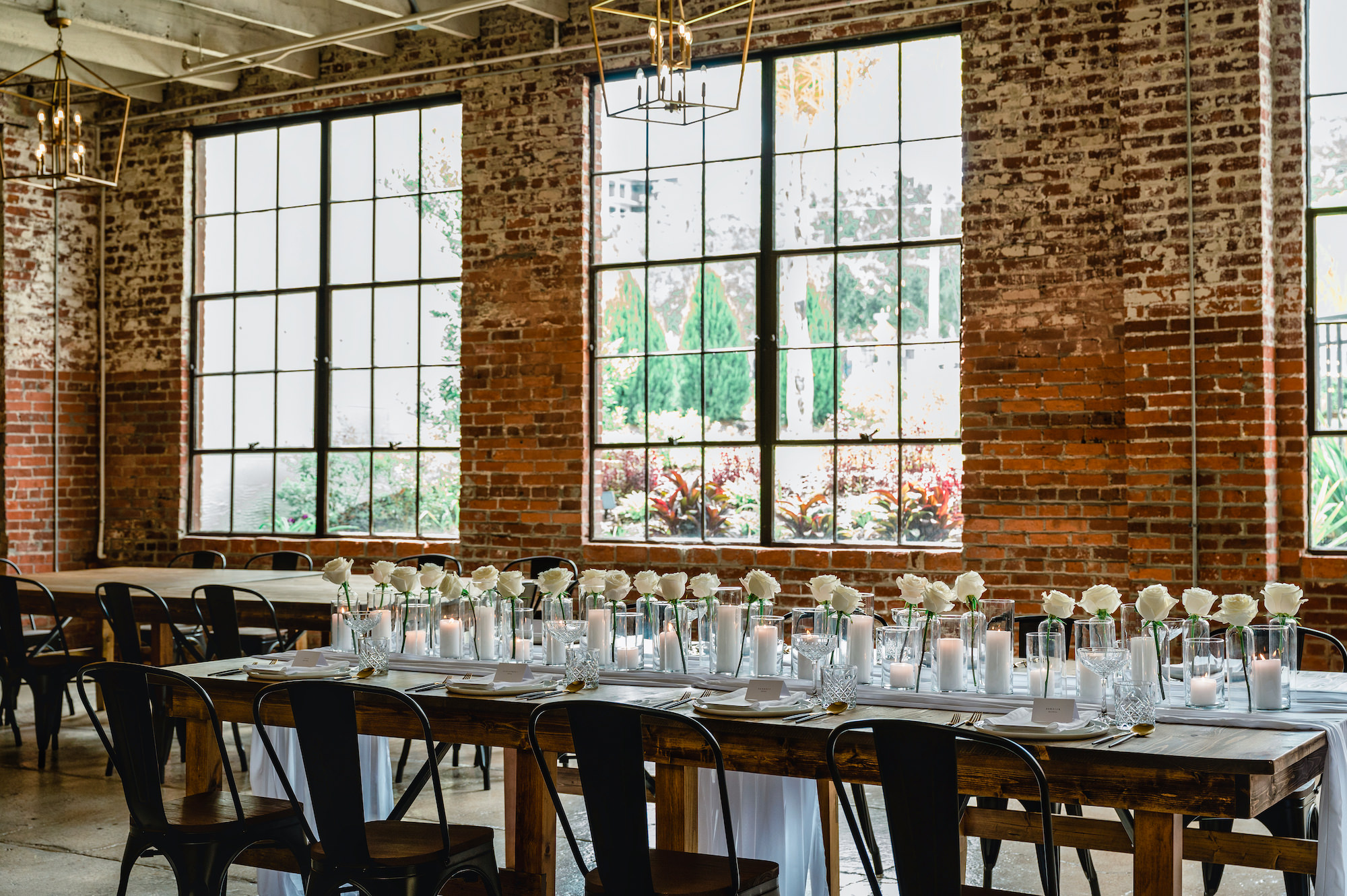 Wooden Wedding Reception Tables with Black Metal Chairs and White Rose Centerpieces | Dade City Florist Save the Date Florida | Venue at the Block
