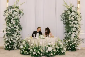 Romantic Sweetheart Table with White and Greenery Floral Arch Backdrop | Timeless Wedding Reception Ideas