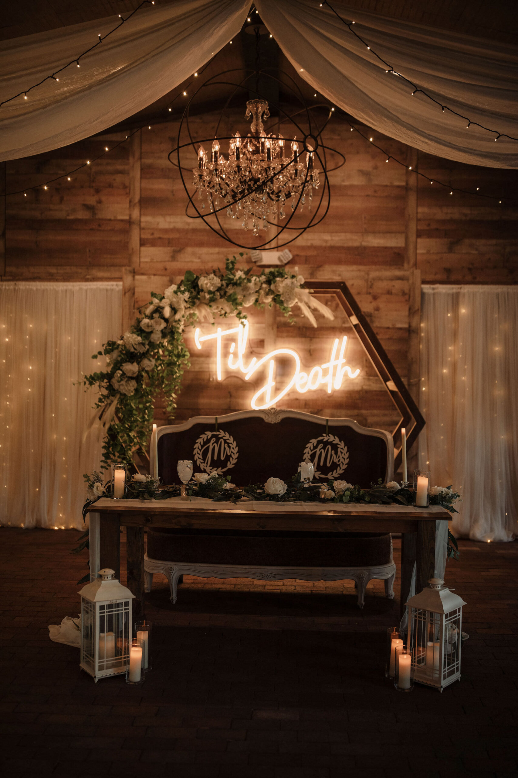 Wedding Reception Sweetheart Table With Hexagon Arch and White Flowers with Greenery and Pampas Grass Decor Ideas | Bench Seating | Personalized Neon Sign Ideas