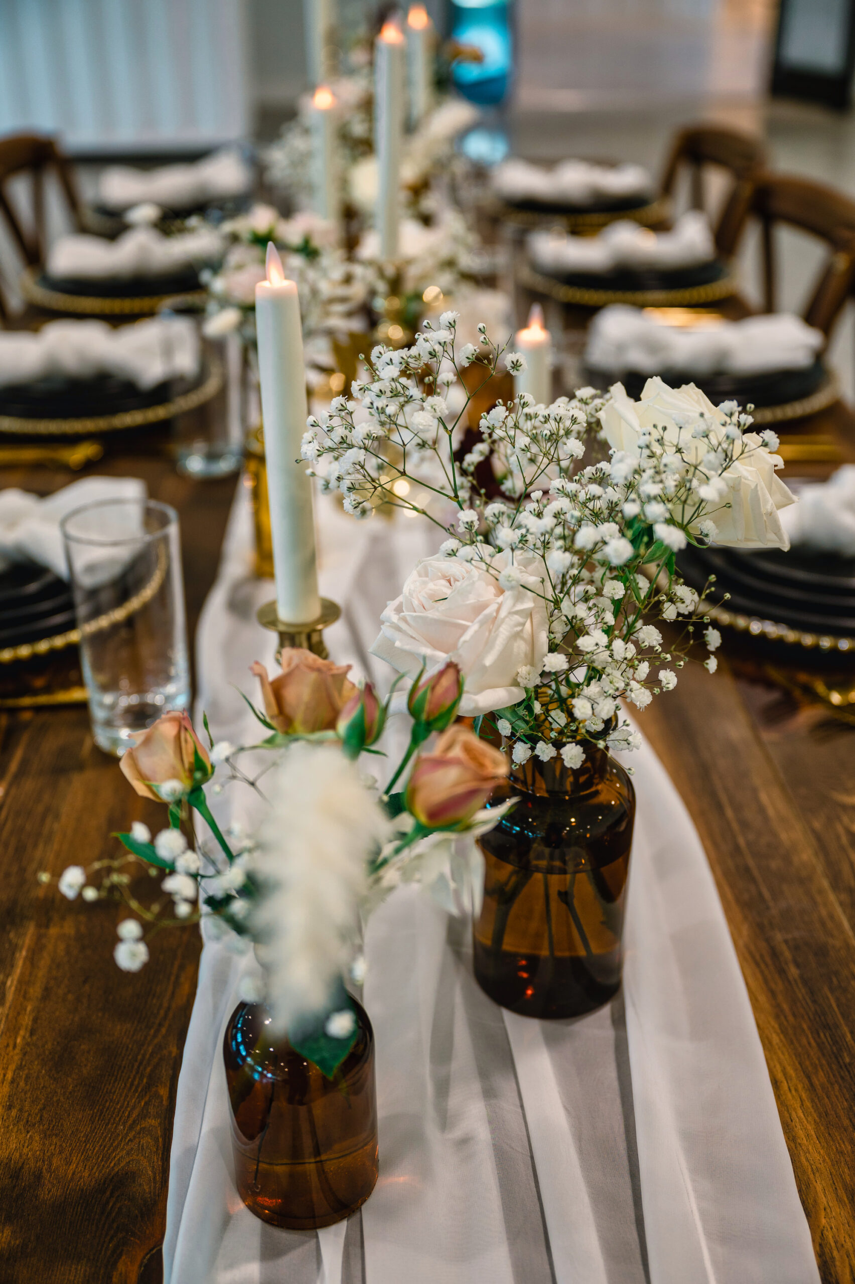 Amber Flower Vases with White and Pink Roses and Baby's Breath Wedding Reception Table Centerpiece Inspiration | Flameless White Taper Candle with Gold Holders | White Chiffon Table Runner Ideas