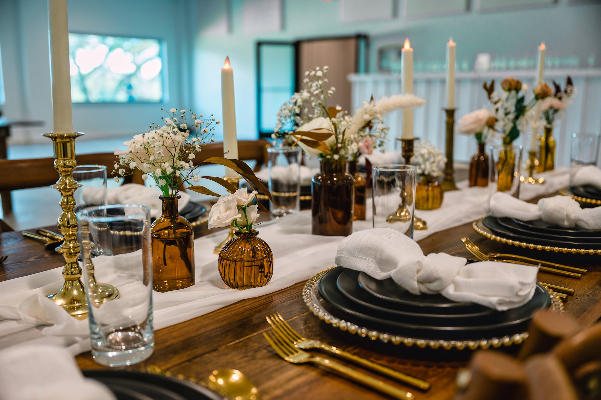 Amber Flower Vases with White Roses and Baby's Breath Wedding Reception Table Centerpiece Inspiration | Flameless White Taper Candle with Gold Holders | Black Plates with Gold Beaded Chargers and Flatware Ideas | Dade City Photographer Iyrus Weddings