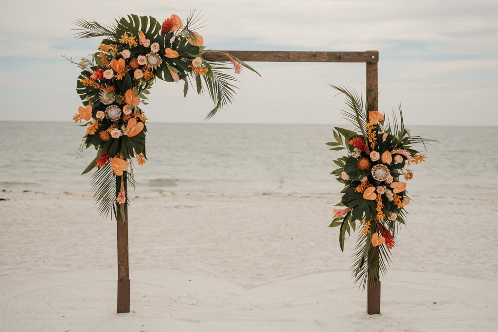 Square Wedding Arch with Tropical Monstera, Orange Anthurium, Palm Leaf, Pink Torch Ginger, King Protea Beach Peach Roses Ceremony Altar Arrangement Ideas | Tampa Bay Florist Save the Date Florida