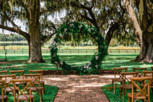 Round Circle Wedding Ceremony Arch with Greenery Inspiration | Wooden Crossback Chairs