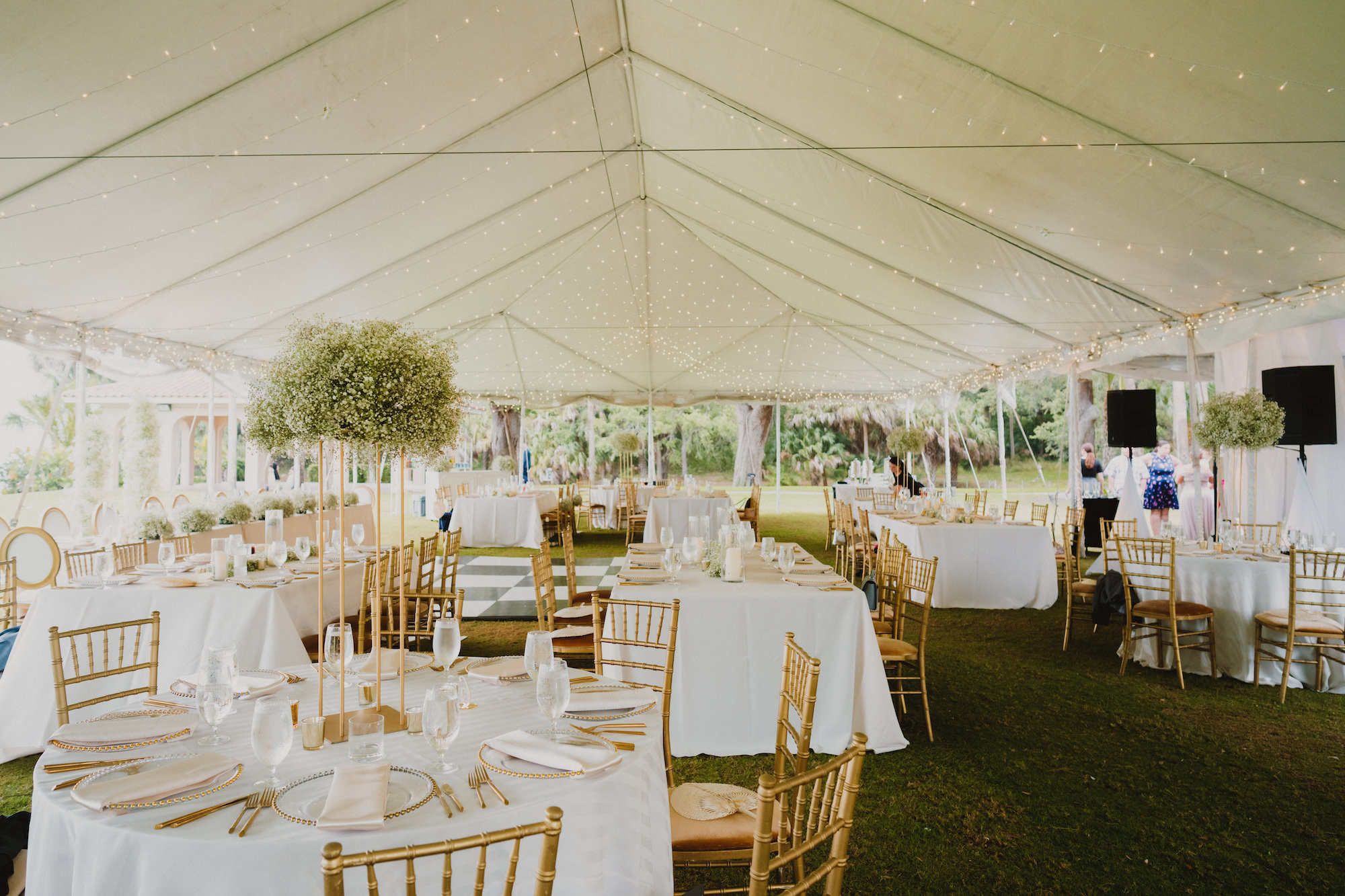 Outdoor Wedding Reception Tent with String Lights | Tall Gold Column Flower Stand with Baby's Breath | Gold Chiavari Chairs | Tampa Bay Planner Kelly Kennedy Weddings and Events