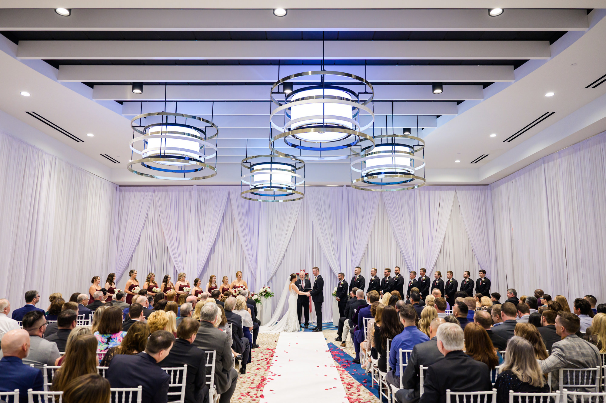 Indoor Wedding Ceremony | White Chiavari Chairs | White Drapery | Tampa Bay Rentals Gabro Event Services | Wyndham Grand Clearwater Beach Wedding Venue