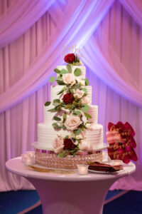 Classic Four-Tiered Round White Wedding Cake with Red and Pink Flowers