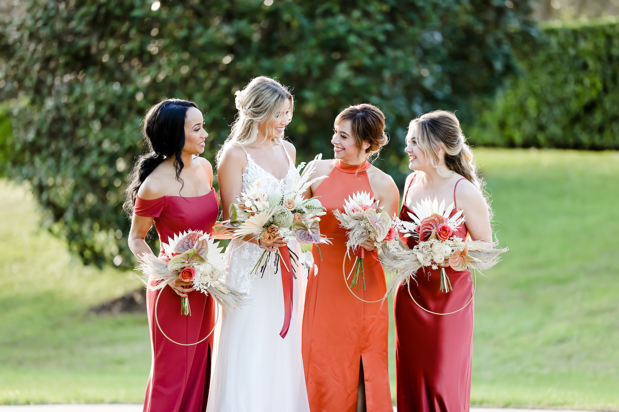 Bridesmaids in Fall Reds and Orange Mix and Match Floor Length Dresses and Unique Circle Boho Wedding Bouquets | Bella Bridesmaids Tampa