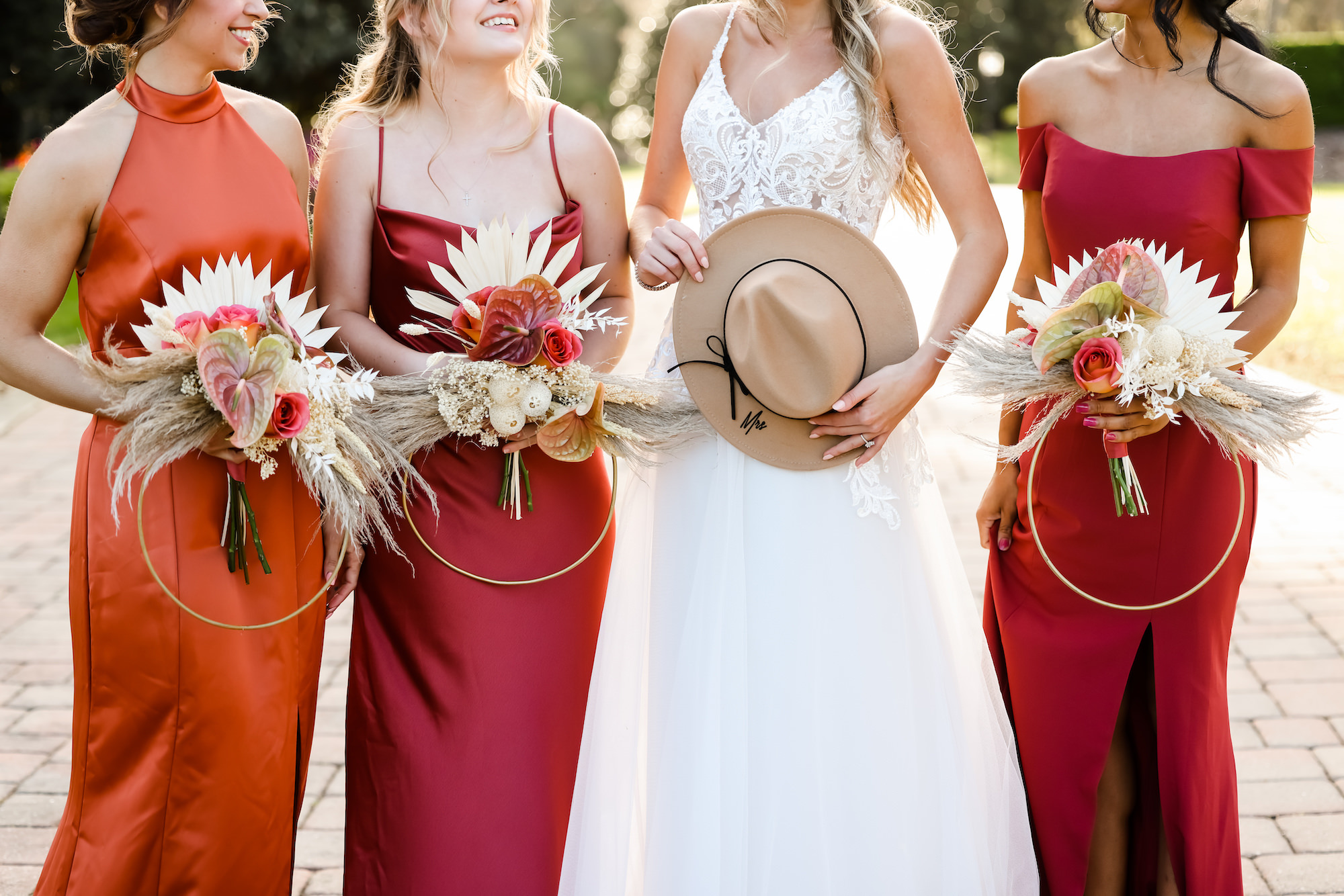 Bride with Bridesmaids in Fall Reds and Orange Mix and Match Floor Length Dresses and Modern Boho Circle Wedding Bouquets | Bella Bridesmaids Tampa