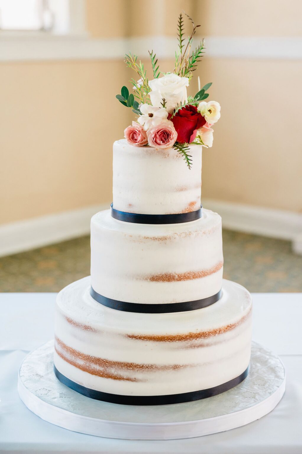 Semi-Naked Wedding Cake with Navy Ribbon Detail and Floral Cake Topper