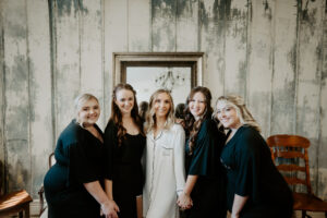 Bride in White PJs getting Ready with Bridesmaids in Green PJs on Wedding Day Portrait