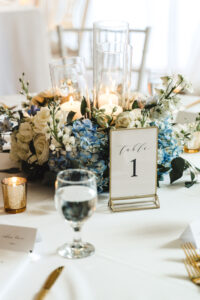 White Roses, Blue Hydrangeas Floral Centerpieces | Classic Gold Frame Table Numbers | Gold Mercury Votives