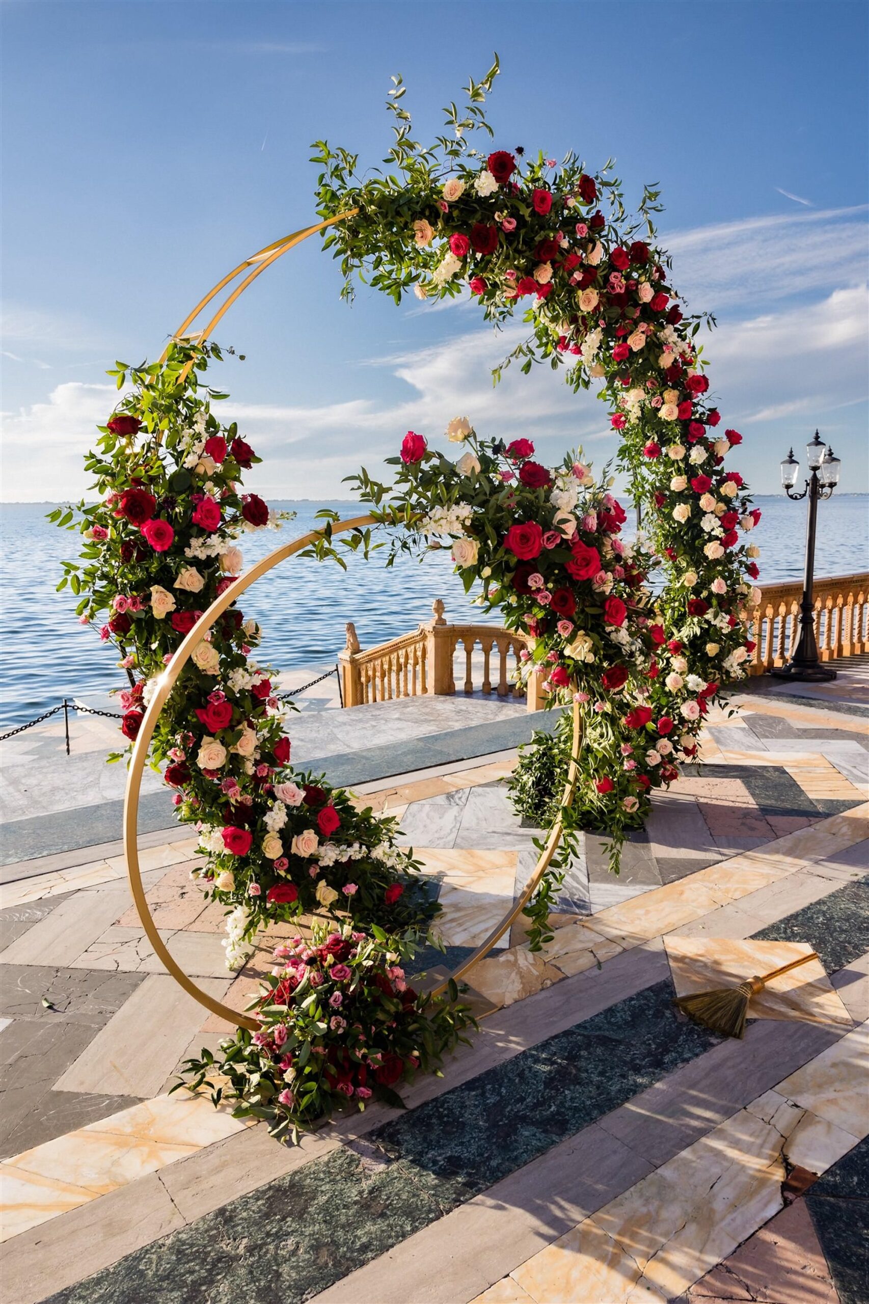 Gold Round Circular Hoop Arch with Red, Burgundy, Pink Roses and Ruscus Greenery | Sarasota Waterfront Wedding Ceremony Venue The Ringling Museum | Florist FH Events