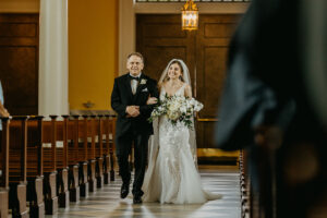 Bride and Father Walking Down Wedding Aisle | White Orchid and Rose with Ruscus Greenery Bridal Bouquet | Tampa Bay Florist Monarch Events and Design