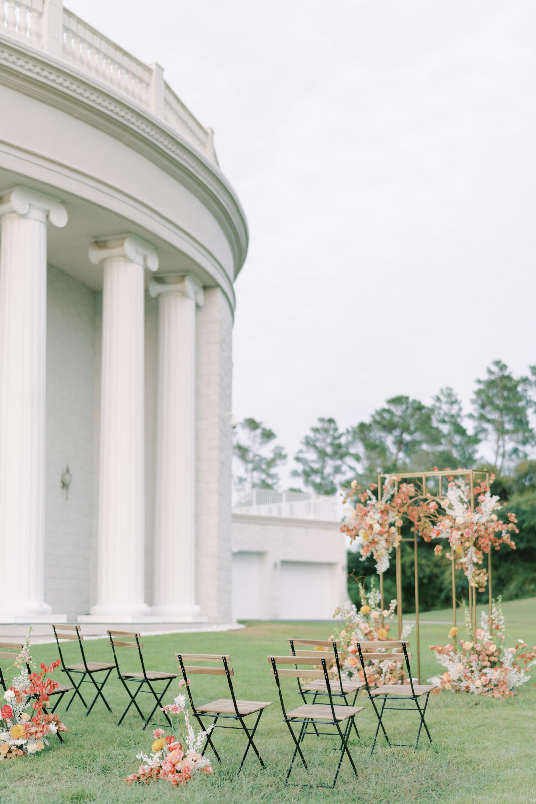Outdoor Spring Garden Wedding Inspiration with Orange, White, Yellow, and Peach Ceremony Arch Flower Arrangements | Modern Wood and Black Metal Chair Seating Ideas | Tampa Bay Venue Whitehurst Gallery