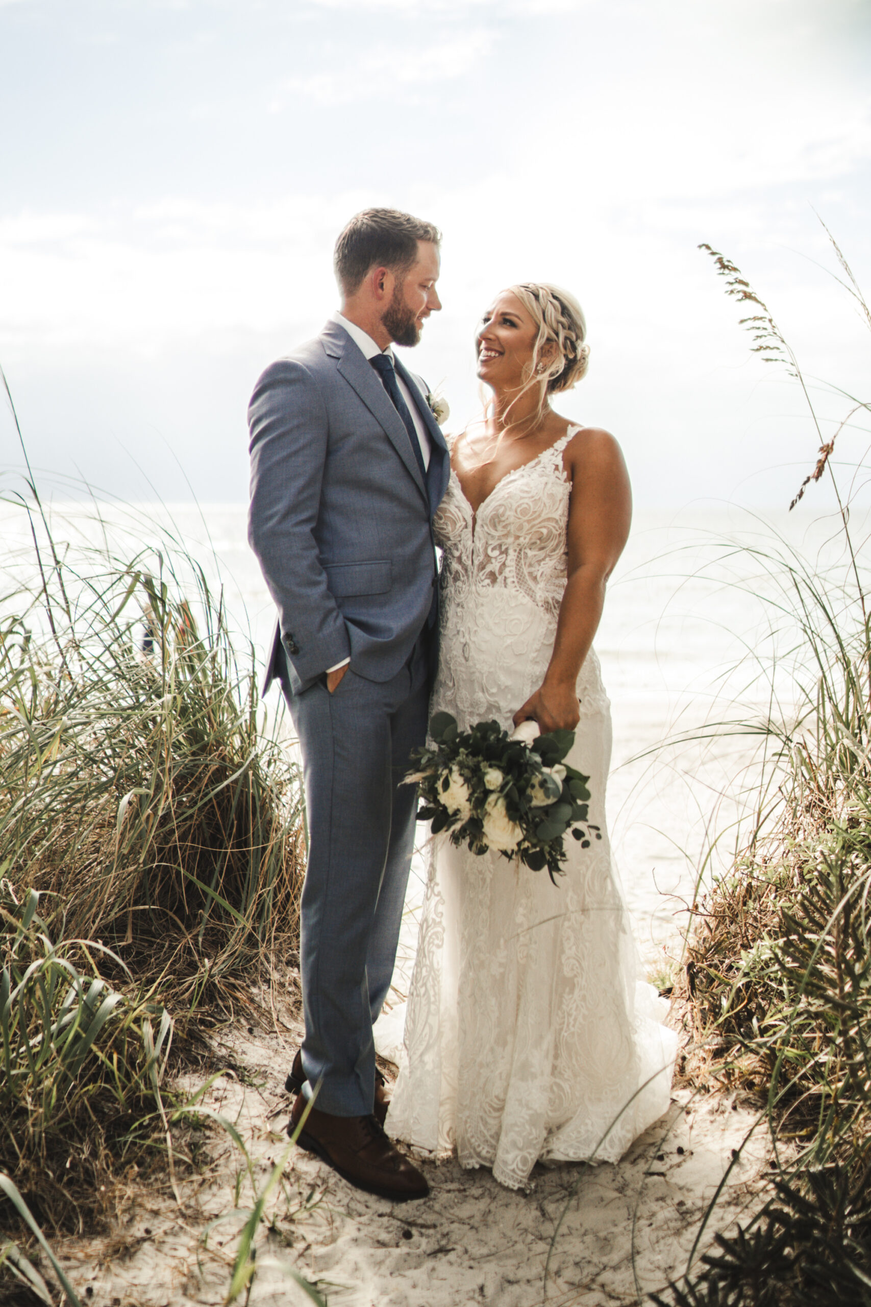 Bride and Groom Treasure Island Beach Wedding Portrait | Ivory Sheer Bodice Lace Mermaid Fit and Flare Wedding Gown Ideas | Tampa Bay Dress Boutique Truly Forever Bridal | Treasure Island Photographer Videographer J&S Media