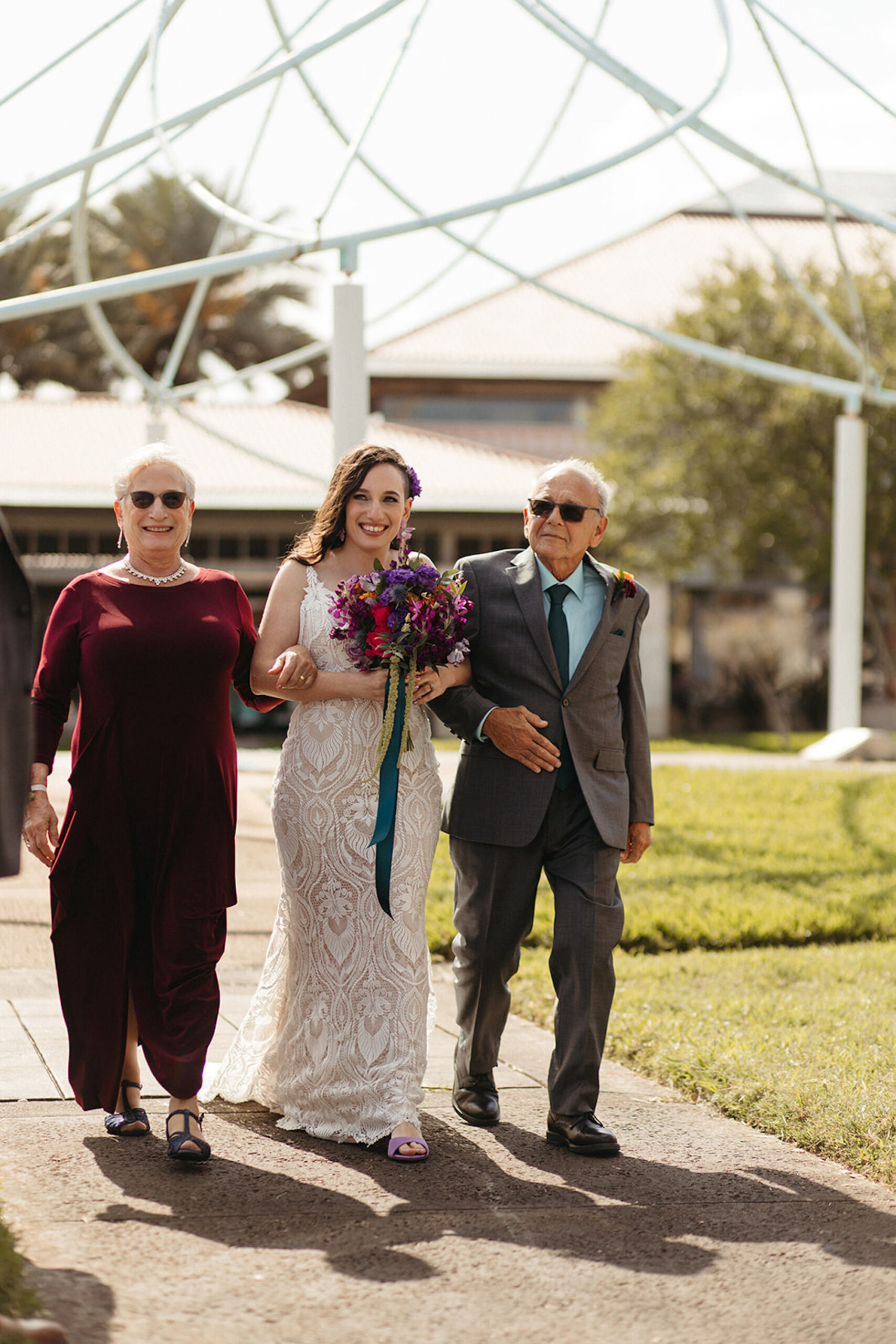 Bride with Father and Mother Walking Down Wedding Aisle