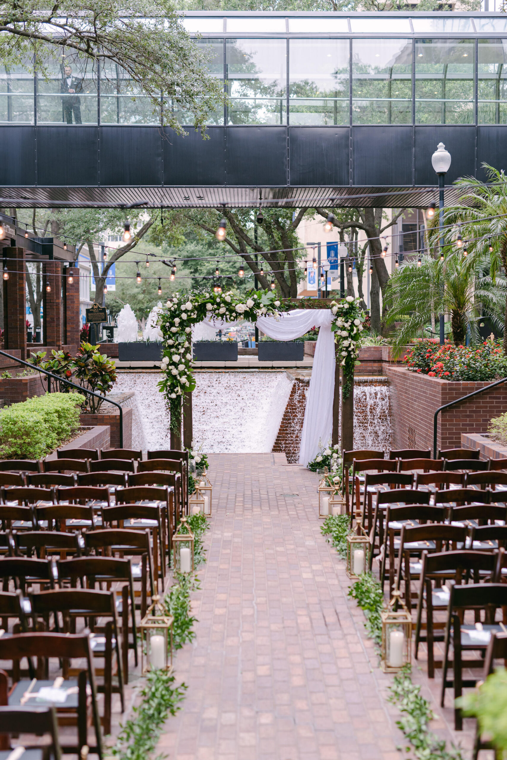 White Rose and Greenery Jewish Chuppah Wedding Ceremony Arch Inspiration | Tampa Wedding Florist FH Events | Outdoor Courtyard Ceremony with Waterfall Fountain Backdrop | Venue Hilton Tampa Downtown