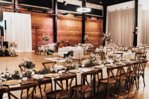 Long Farmhouse Feasting Tables | Elegant Boho Wedding Inspiration | Wooden Crossback Chairs | White Linen | Tall Flower Stand with Eucalyptus, Fern, Pampas Grass, Roses Centerpieces | Modern Industrial Exposed Brick Venue Ideas | Alternative Seating Lounge Furniture | Tampa Bay Kate Ryan Event Rentals